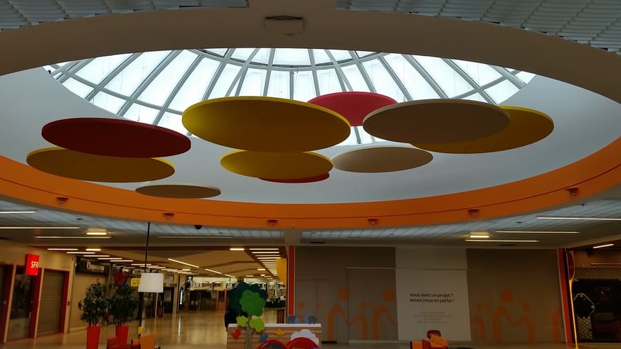 Panneaux acoustiques suspendus Echo Performance installés dans un magasin Carrefour — traitement acoustique Paris